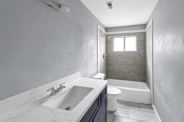 full bathroom featuring toilet, a textured ceiling, tiled shower / bath, and vanity