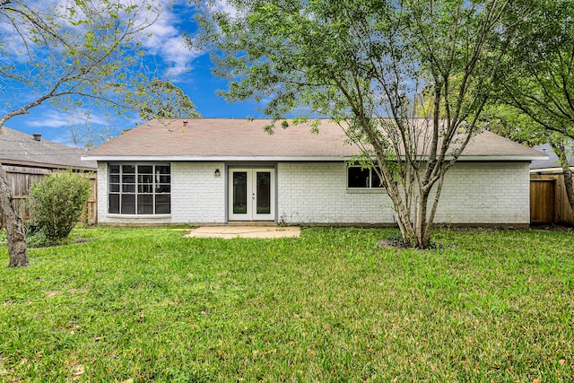 rear view of house with a lawn and french doors