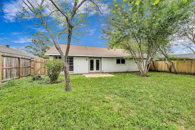 rear view of house featuring french doors and a yard