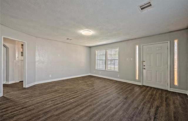 entrance foyer with a textured ceiling and dark hardwood / wood-style floors