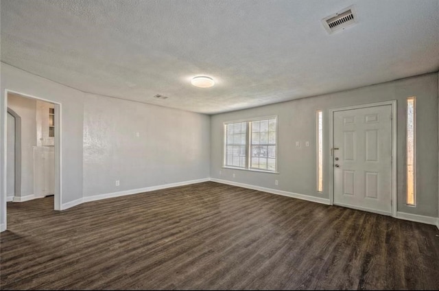 entryway featuring dark wood-type flooring and a textured ceiling