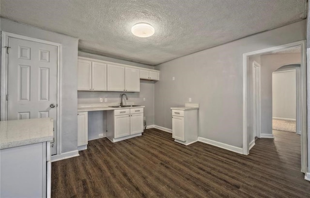 kitchen featuring white cabinets, dark hardwood / wood-style floors, sink, and a textured ceiling