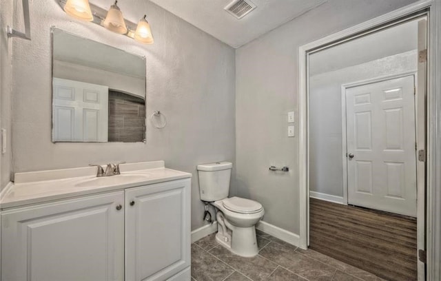 bathroom with hardwood / wood-style floors, vanity, and toilet