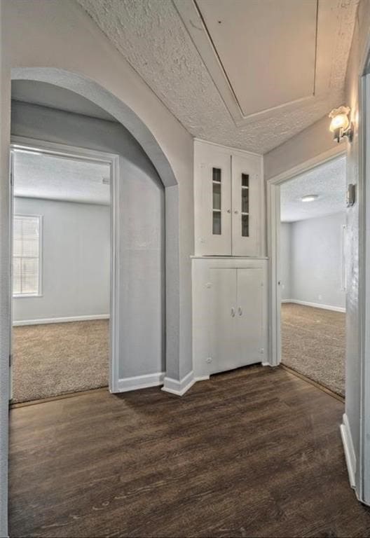 corridor with dark wood-type flooring and a textured ceiling