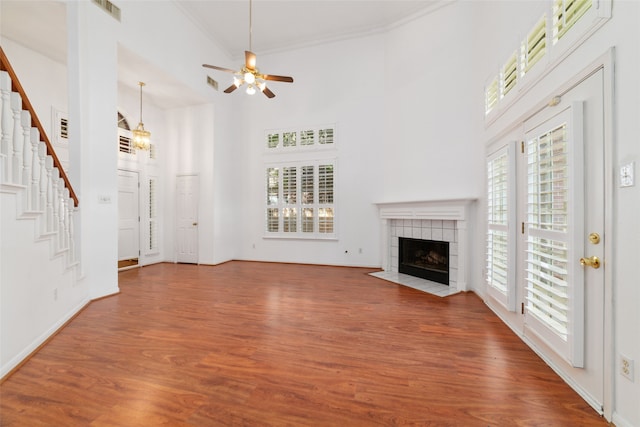 unfurnished living room with hardwood / wood-style flooring, a towering ceiling, and a wealth of natural light