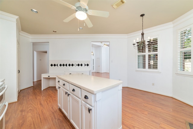 kitchen featuring white cabinets, a kitchen island, light wood-type flooring, and hanging light fixtures