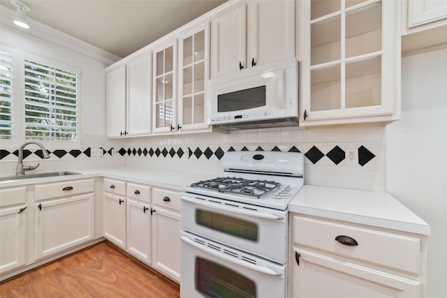 kitchen featuring white cabinets, white appliances, light hardwood / wood-style flooring, and sink