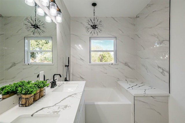 bathroom featuring a washtub, vanity, and plenty of natural light