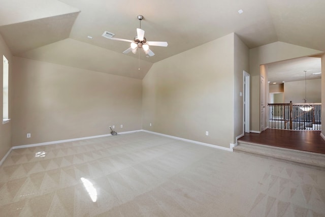 interior space with lofted ceiling, ceiling fan with notable chandelier, and light colored carpet