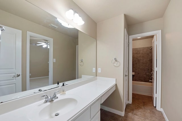 bathroom with tile patterned floors, vanity, and tiled shower / bath combo