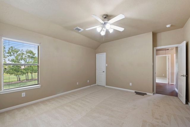 unfurnished bedroom with ceiling fan, lofted ceiling, and light carpet