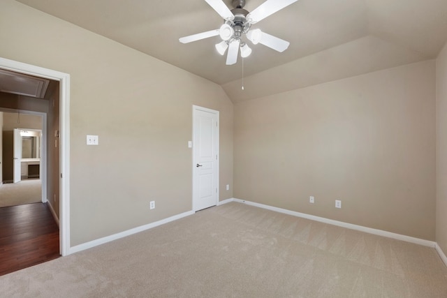 spare room with vaulted ceiling, light colored carpet, and ceiling fan