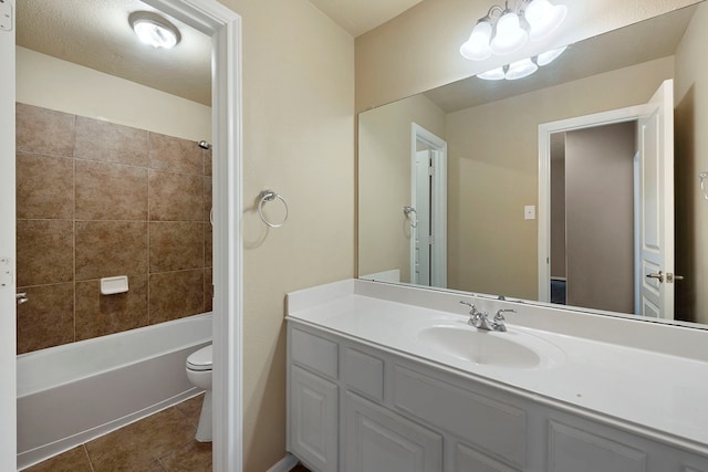 full bathroom featuring vanity, tiled shower / bath, tile patterned floors, and toilet