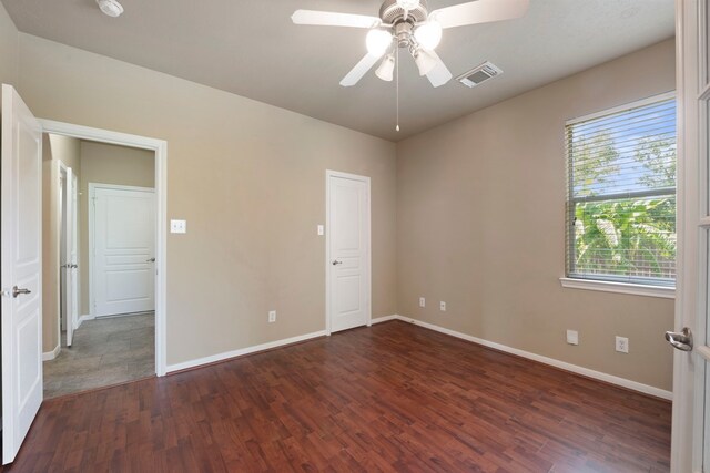 unfurnished bedroom with ceiling fan and dark hardwood / wood-style floors