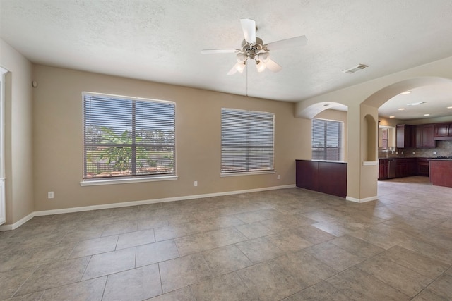 empty room with a textured ceiling and ceiling fan