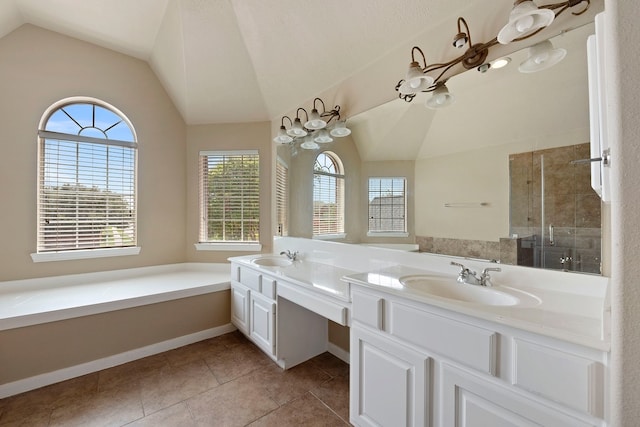 bathroom featuring tile patterned flooring, vanity, vaulted ceiling, and walk in shower