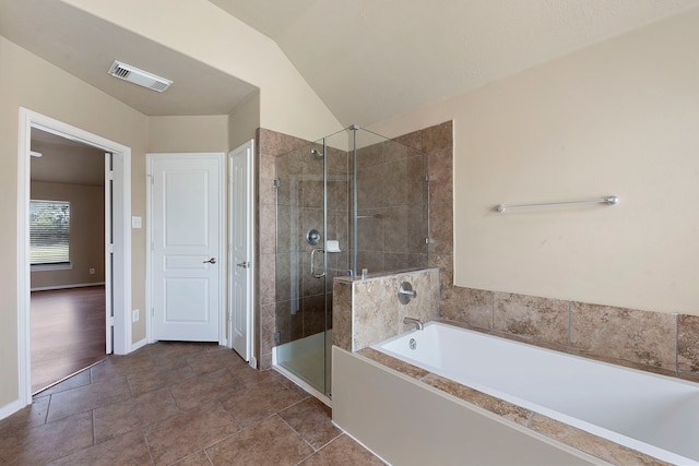 bathroom featuring lofted ceiling, plus walk in shower, and tile patterned flooring