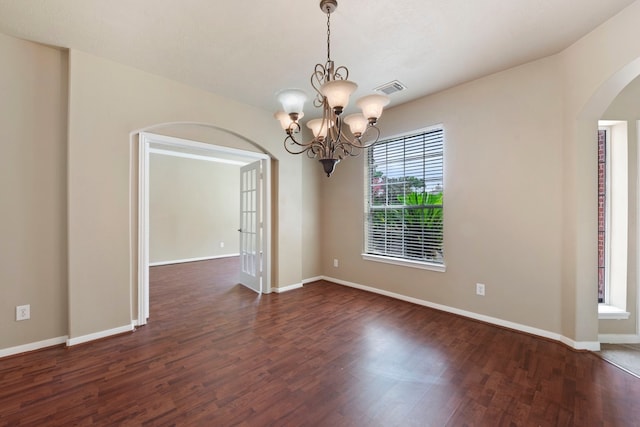 unfurnished room with dark hardwood / wood-style flooring and an inviting chandelier