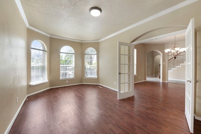 spare room featuring crown molding, dark hardwood / wood-style flooring, and a textured ceiling