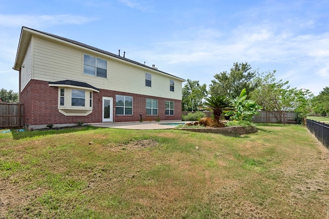 rear view of property with a yard and a patio