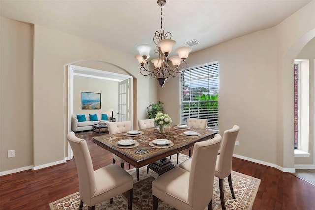 dining area featuring an inviting chandelier and dark hardwood / wood-style flooring