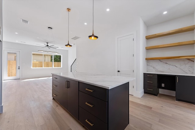 kitchen with decorative light fixtures, light wood-style floors, decorative backsplash, and visible vents