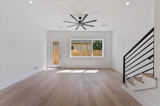 unfurnished living room with light wood-style floors, ceiling fan, recessed lighting, stairs, and baseboards
