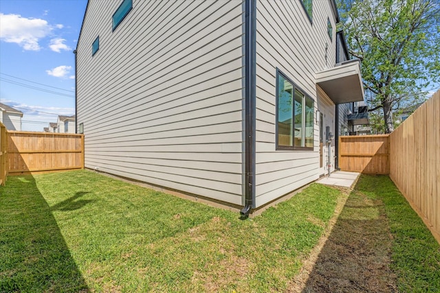view of side of home with a yard and a fenced backyard