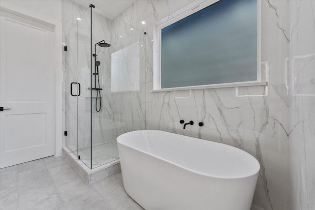 bathroom featuring a marble finish shower, tile walls, marble finish floor, and a soaking tub