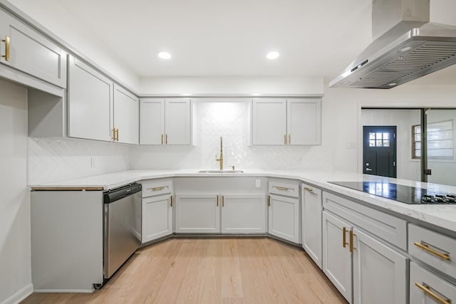 kitchen featuring stainless steel dishwasher, black electric cooktop, sink, wall chimney range hood, and light hardwood / wood-style flooring