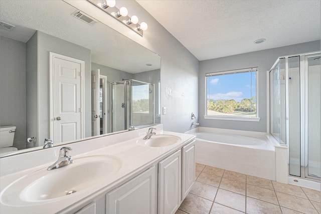 bathroom featuring tile patterned flooring, a stall shower, and a sink