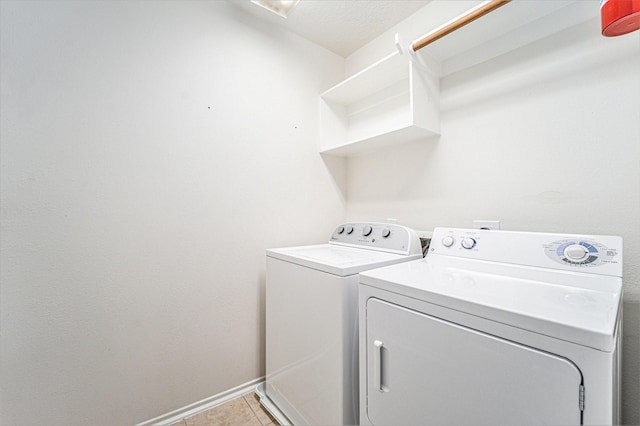 laundry area with light tile patterned floors, laundry area, washer and dryer, and baseboards