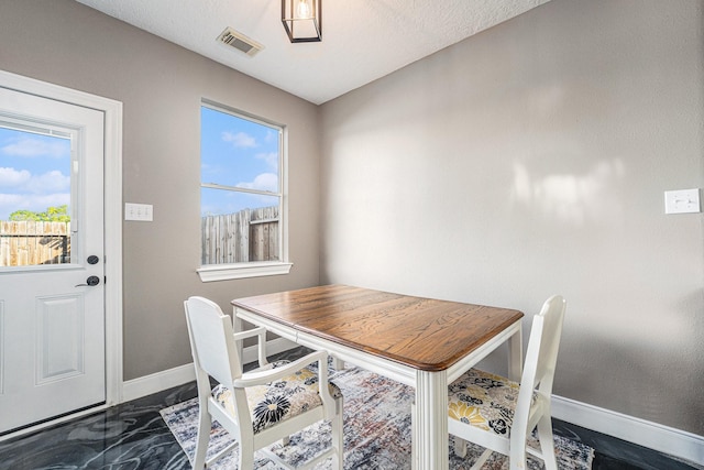 dining area with a wealth of natural light, visible vents, marble finish floor, and baseboards