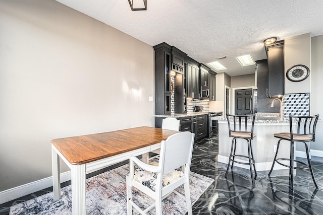 dining room featuring marble finish floor, a textured ceiling, and baseboards