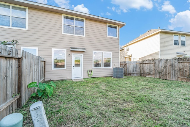 back of property featuring a lawn, cooling unit, and a fenced backyard