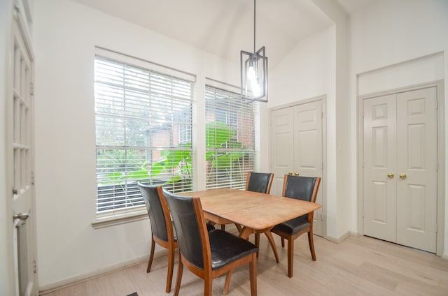 dining space featuring light wood-type flooring, plenty of natural light, and lofted ceiling