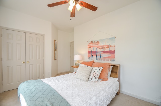 carpeted bedroom with ceiling fan and a closet