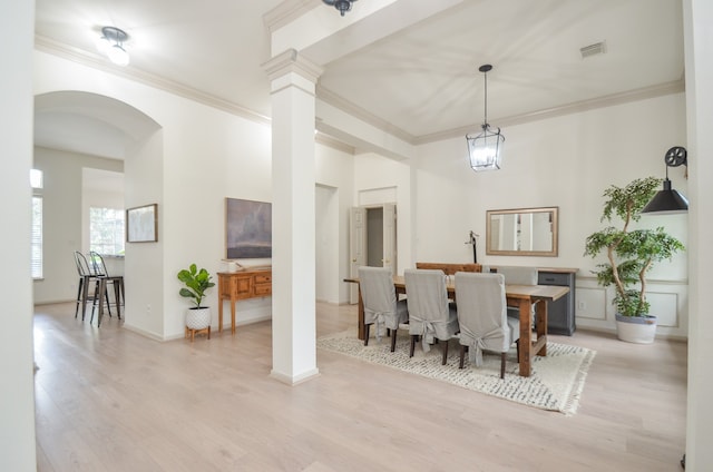 dining space featuring light wood-type flooring, ornamental molding, and a chandelier