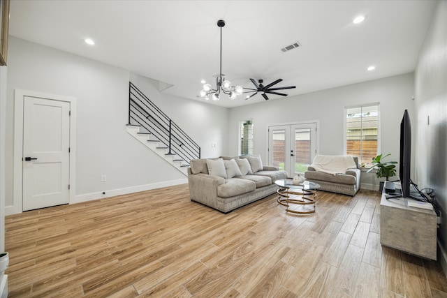 living room with french doors, ceiling fan with notable chandelier, and light hardwood / wood-style floors