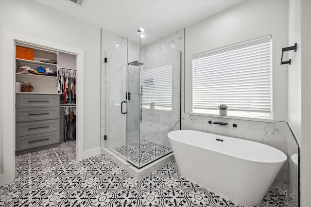 bathroom with tile patterned floors and shower with separate bathtub