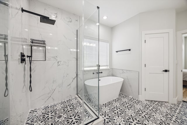 bathroom with tile patterned floors, tile walls, and plus walk in shower