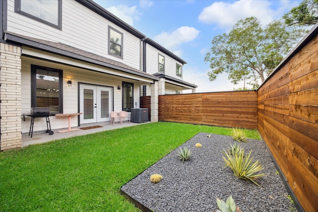 view of yard with cooling unit and french doors