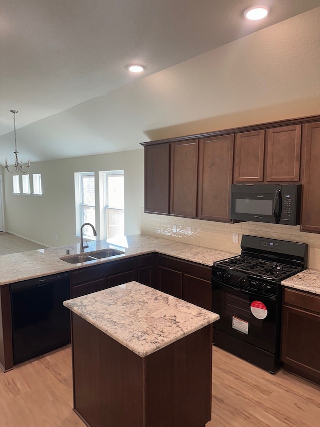 kitchen featuring black appliances, lofted ceiling, sink, and light hardwood / wood-style flooring