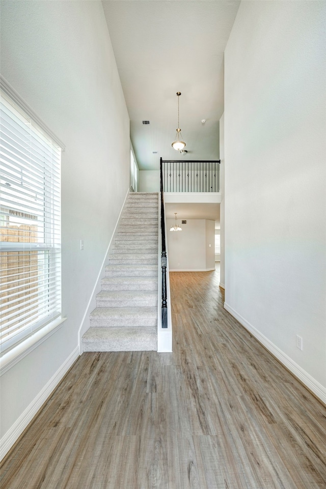 stairway featuring a high ceiling and hardwood / wood-style flooring