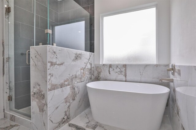 9339 Lavender St, North Houston, TX 77016 - bathroom with marble tiled flooring, a shower stall, a soaking tub, and tile walls