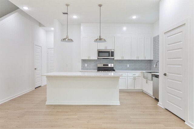 9339 Lavender St, North Houston, TX 77016 - kitchen featuring appliances with stainless steel finishes, a sink, light wood-style flooring, decorative backsplash, and recessed lighting
