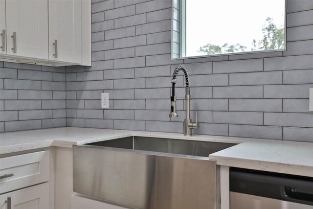 9339 Lavender St, North Houston, TX 77016 - kitchen featuring decorative backsplash, stainless steel dishwasher, healthy amount of natural light, and light stone countertops