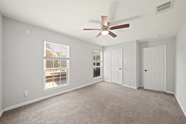 carpeted spare room featuring ceiling fan