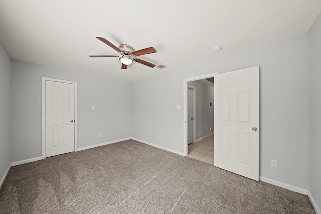 empty room featuring ceiling fan and light colored carpet