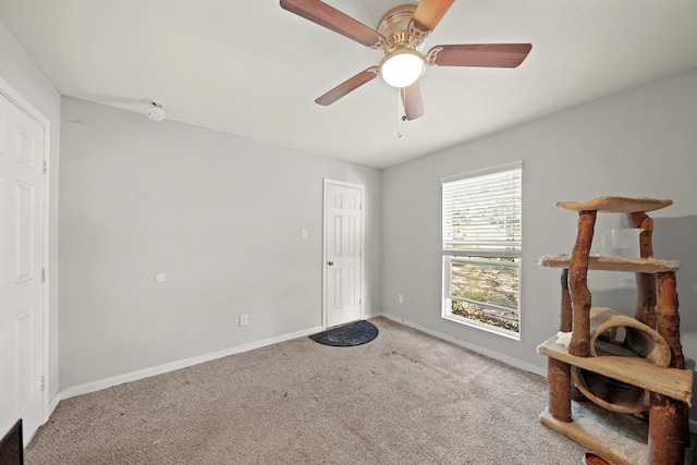 interior space featuring ceiling fan and light colored carpet